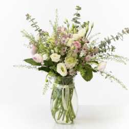 Mixed pastel bouquet in a clear glass vase with a ribbon