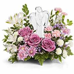 Pink and white floral arrangement with an angel figurine