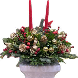 Holiday centerpiece with red candles in a white pedestal vase