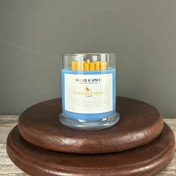 Blue jar candle with yellow wax center on stacked wooden stands