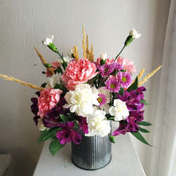 Mixed bouquet of carnations, daisies, and alstroemeria in a metal vase