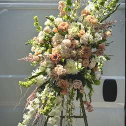 Large peach and white floral spray on an easel