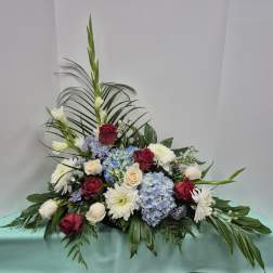 Low floral arrangement with roses, hydrangeas, and white blooms