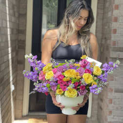 Woman holding a large bouquet in a white vase