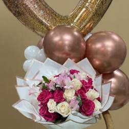 Heart-shaped balloons above a bouquet of pink and white roses