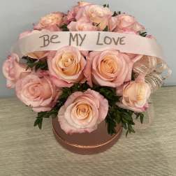 Pink rose bouquet in a round box with a "Be My Love" ribbon