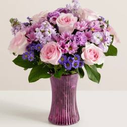 Pink and purple mixed bouquet in a tall purple vase