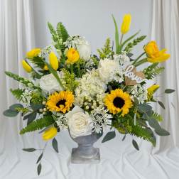Yellow tulips and white roses arranged in a gray vase