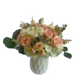 Peach and white rose bouquet in a white vase
