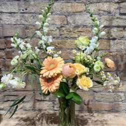 Peach and yellow mixed bouquet in a clear glass vase