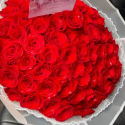 Large bouquet of red roses wrapped in white paper
