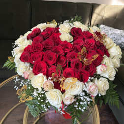 Heart-shaped bouquet of red and white roses with butterfly picks