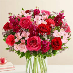 Bouquet of red and pink roses in a clear glass vase