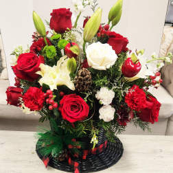 Red and white floral arrangement in a black basket with ribbon