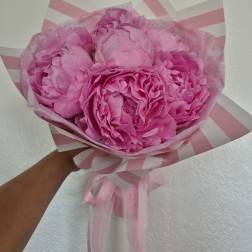 Pink peony bouquet wrapped in striped pink paper with ribbon