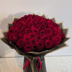 Large bouquet of red roses wrapped in black and gold paper