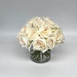 Cream rose bouquet in a clear glass vase