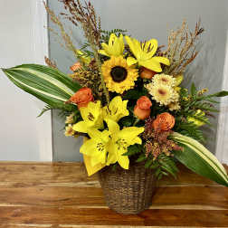 Yellow lilies and orange roses in a wicker basket