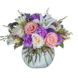 Bouquet of pink and white roses with purple flowers in a glass vase