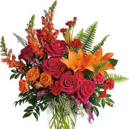 Bright bouquet of roses and orange lilies in a clear glass vase