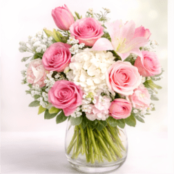 Pink roses and lilies arranged in a clear glass vase