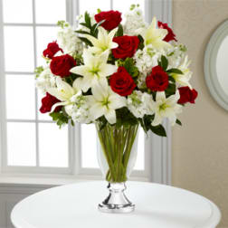 Red roses and white lilies in a clear glass vase