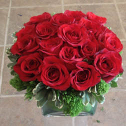 Red roses arranged in a low glass vase