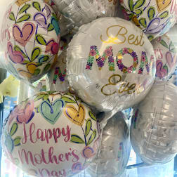 Cluster of Mother's Day balloons with colorful heart patterns and floral text
