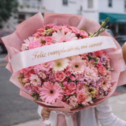 Pink mixed flower bouquet wrapped in pink paper with a birthday ribbon