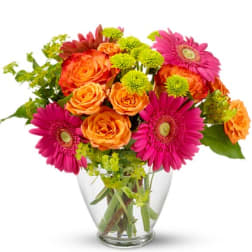 Bouquet of orange roses and pink gerbera daisies in a clear glass vase