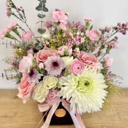 Pink and white bouquet with roses, chrysanthemums, and small filler flowers in a dark vase