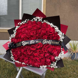 Large bouquet of red roses with white baby's breath and a black ribbon