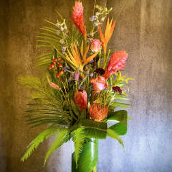 Tall tropical flower arrangement in a clear glass vase