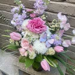 Pink and lavender bouquet with roses, tulips, and a butterfly accent