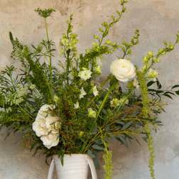 Tall white floral arrangement in a white vase