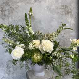 White roses and mixed white flowers in a white vase