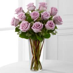 Lavender roses arranged in a clear glass vase