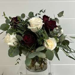 Bouquet of white and deep red roses in a clear glass vase