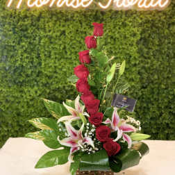Red roses and pink lilies arranged in a basket