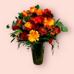 Bouquet of red, orange, and yellow flowers in a tall glass vase