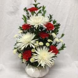 White spider mums and red carnations in a white vase