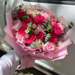Pink rose bouquet with small white daisies wrapped in pink paper