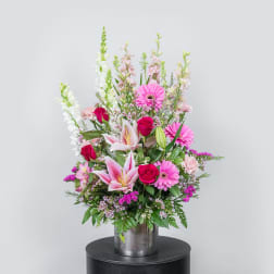 Tall mixed bouquet with pink lilies, roses, and gerbera daisies in a metal vase