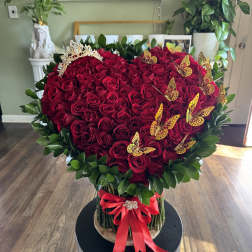 Heart-shaped bouquet of red roses with butterflies and a red ribbon