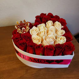 Heart-shaped box of red and cream roses with a small crown topper