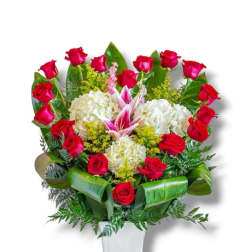 Red roses and white hydrangeas in a white vase