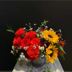 Bouquet of red roses and yellow sunflowers in a metal vase