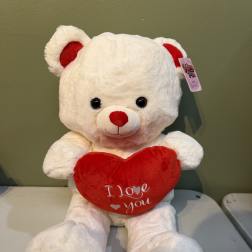 White teddy bear holding a red heart with "I love you" text