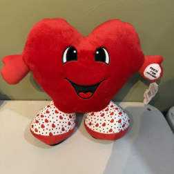Red heart-shaped plush toy with a smiling face and patterned feet