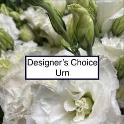 White flowers with green buds and a label reading Designer’s Choice Urn
